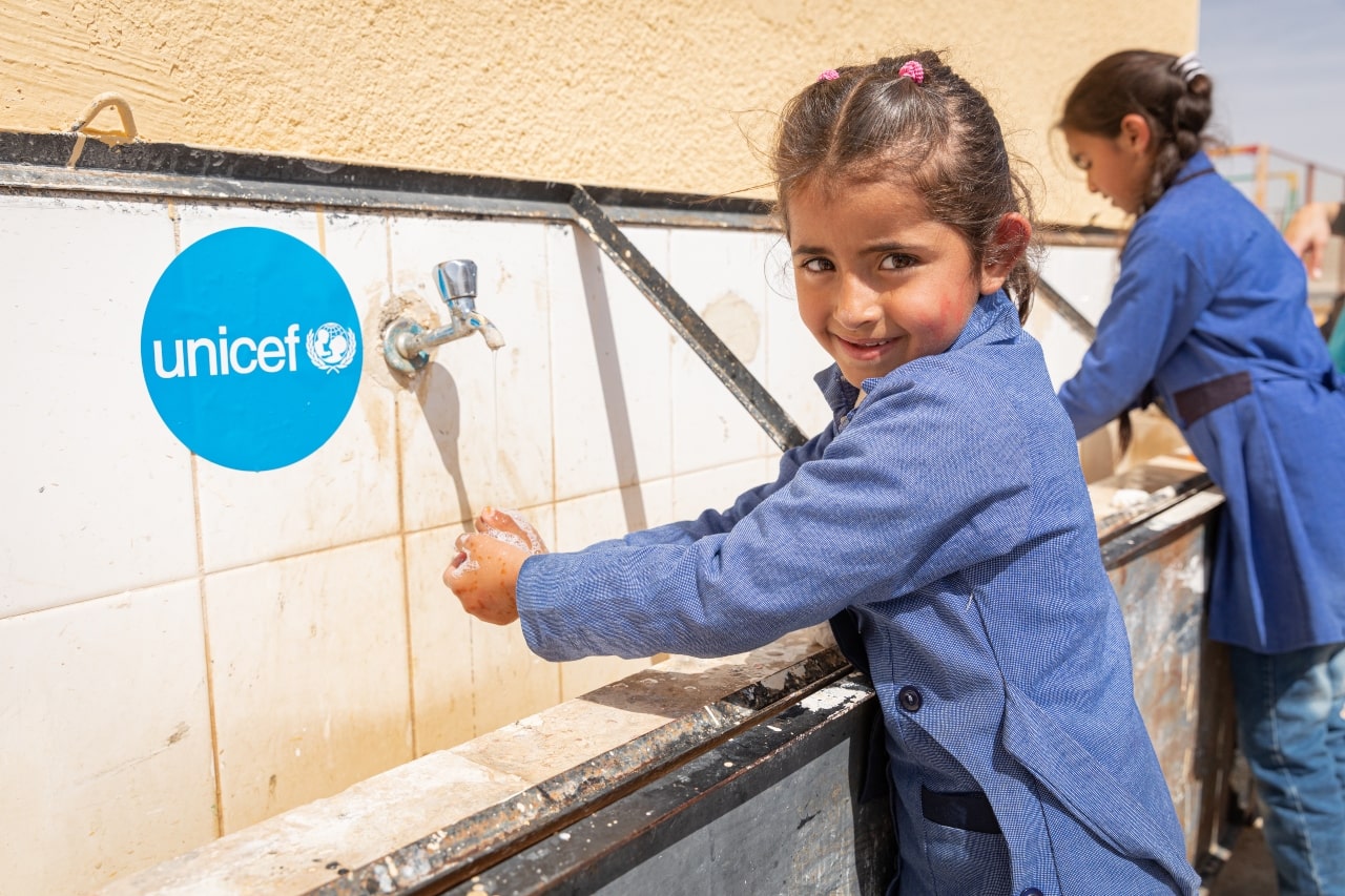 Niñas y niños en Colombia lavándose las manos como parte de un programa de higiene de UNICEF.