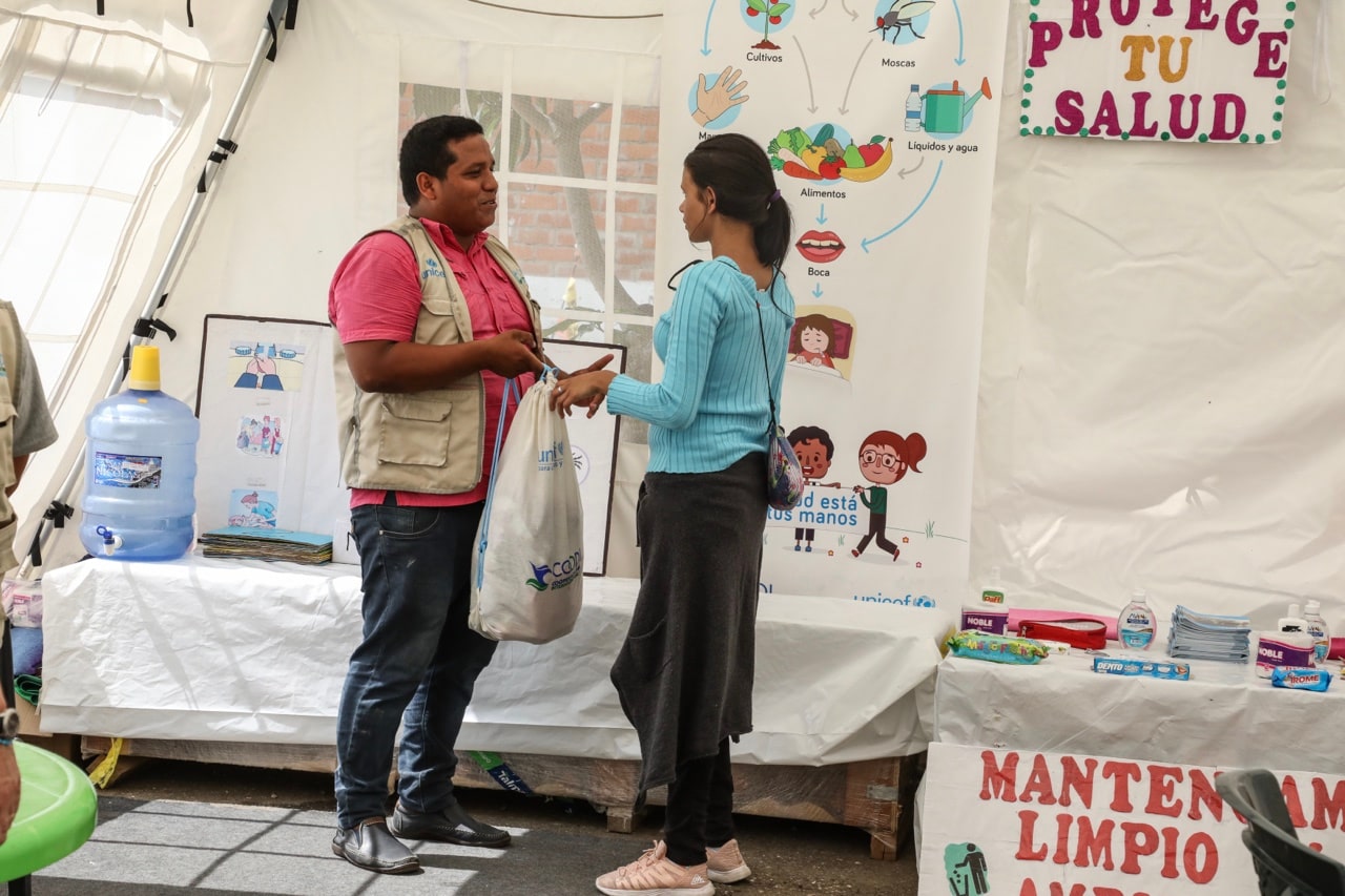 mujer recibiendo kit de donación en labor comunitaria-Unicef Colombia