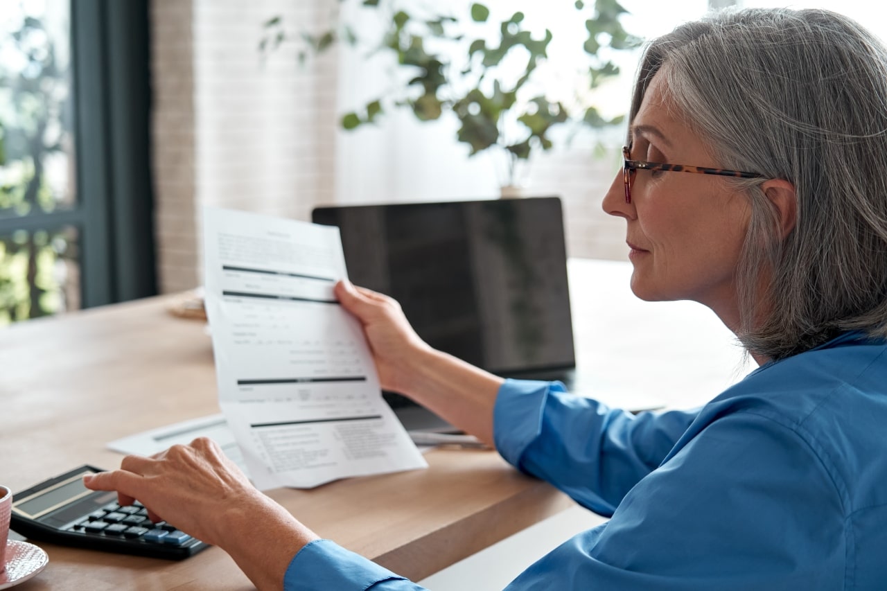 Mujer mayor revisando las finanzas de su hogar