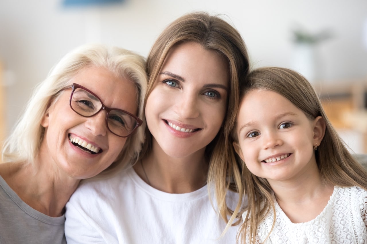 Retrato de familia de tres generaciones, abuela mamá e hija sonrientes