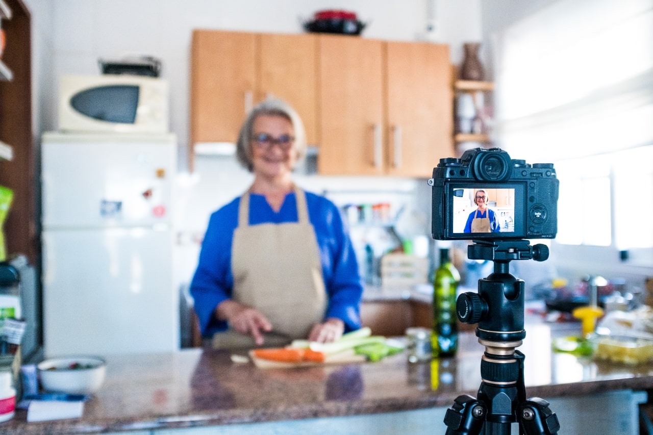 mujer influyente frente a la cámara se graba preparando una receta de cocina para sus redes sociales
