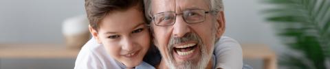 Abuelo feliz y nieto se divierten juntos jugando en casa