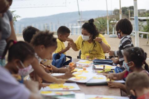 Maestra imparte clases de arte a un grupo de niños y niñas en Colombia.  