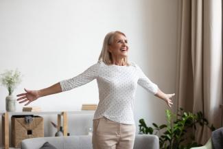 Mujer feliz Mujer mayor sonriente parada con los brazos abiertos disfrutando de un momento feliz