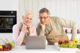 Pareja feliz haciendo cursos online para adultos mayores sobre cocina Pareja feliz haciendo cursos online para adultos mayores sobre cocina