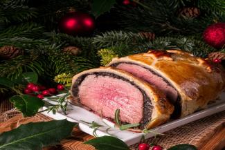un beef wellington término medio, adornado con hojas navideñas.